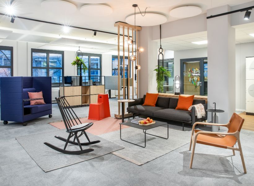 Offene Wartezone im Empfangsbereich mit Sofa, Sesseln, Besprechungsnische und Couchtisch als Bereich für Besucher vor dem Check-in.