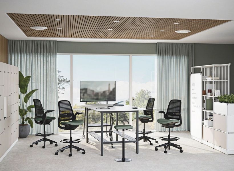 Open-Space-Arbeitsbereich mit Schreibtischen, großen Pflanzen in Hochkübeln und ruhiger Atmosphäre durch integrierte Begrünung.