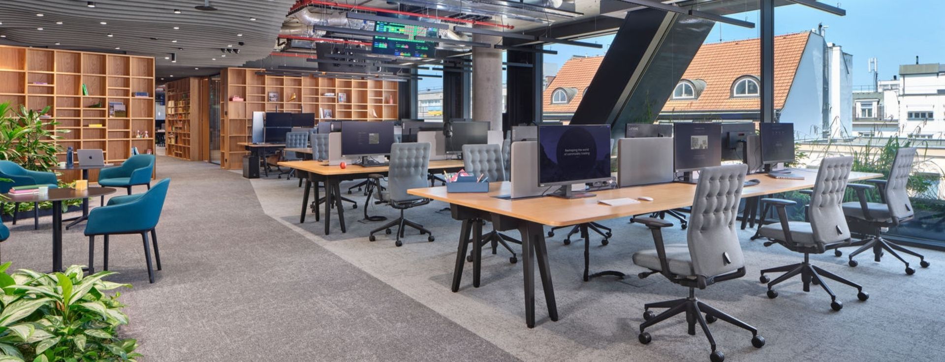 Großraumbüro mit klar gegliederten Arbeits- und Kommunikationszonen, raumteilenden Regalen und modernen Arbeitsplätzen als Beispiel für eine durchdachte Zonenplanung im offenen Büro.