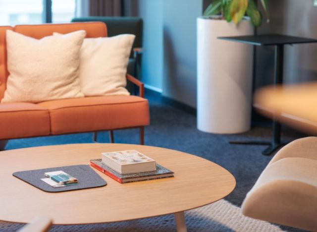 Wartebereich im Empfang mit Sofa, Sesseln und rundem Couchtisch mit Zeitschriften als Sitzgelegenheit für Besucher.
