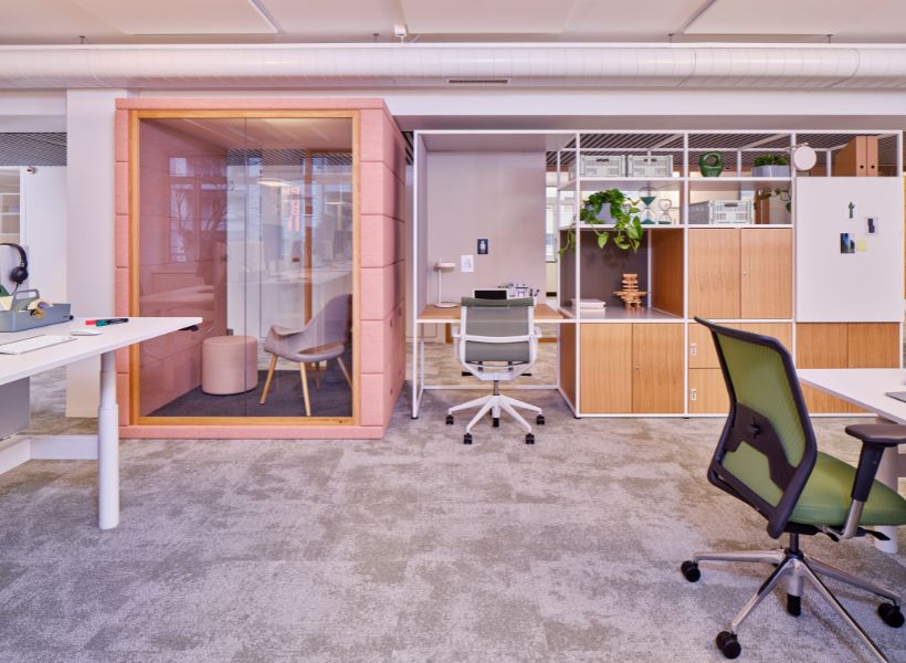 Open-Space-Büro mit integrierter Rückzugsbox, Arbeitsplatz und Stauraum für konzentriertes Arbeiten innerhalb einer offenen Struktur.